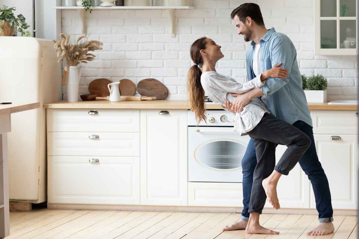 Coppia felice che balla in cucina